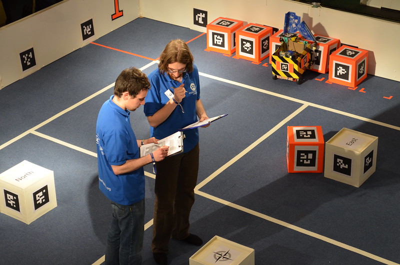 Two blue shirted volunteers stood in the middle of the arena comparing notes on their clipboards